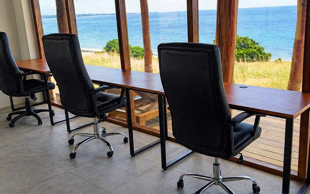 Coworking desks facing the ocean through open timber columns